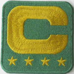May include: Green felt patch with a large yellow embroidered letter "C" and four yellow embroidered stars below.