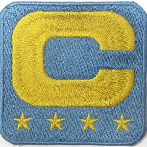 May include: A blue embroidered patch with a large yellow letter C and four yellow stars below it.