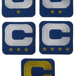 May include: Five embroidered patches with a blue background and a white or gold letter "C" in the center. Each patch has four gold stars at the bottom.