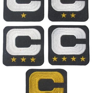 May include: Five black embroidered patches featuring a white letter "C" with varying numbers of gold stars below. One patch has a gold "C". The patches are square with rounded corners.