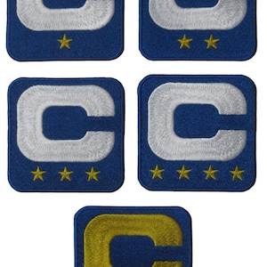 May include: A set of blue, square patches featuring a white embroidered letter "C" and gold stars. The patches display varying numbers of stars, from one to four, and one patch has a gold "C".