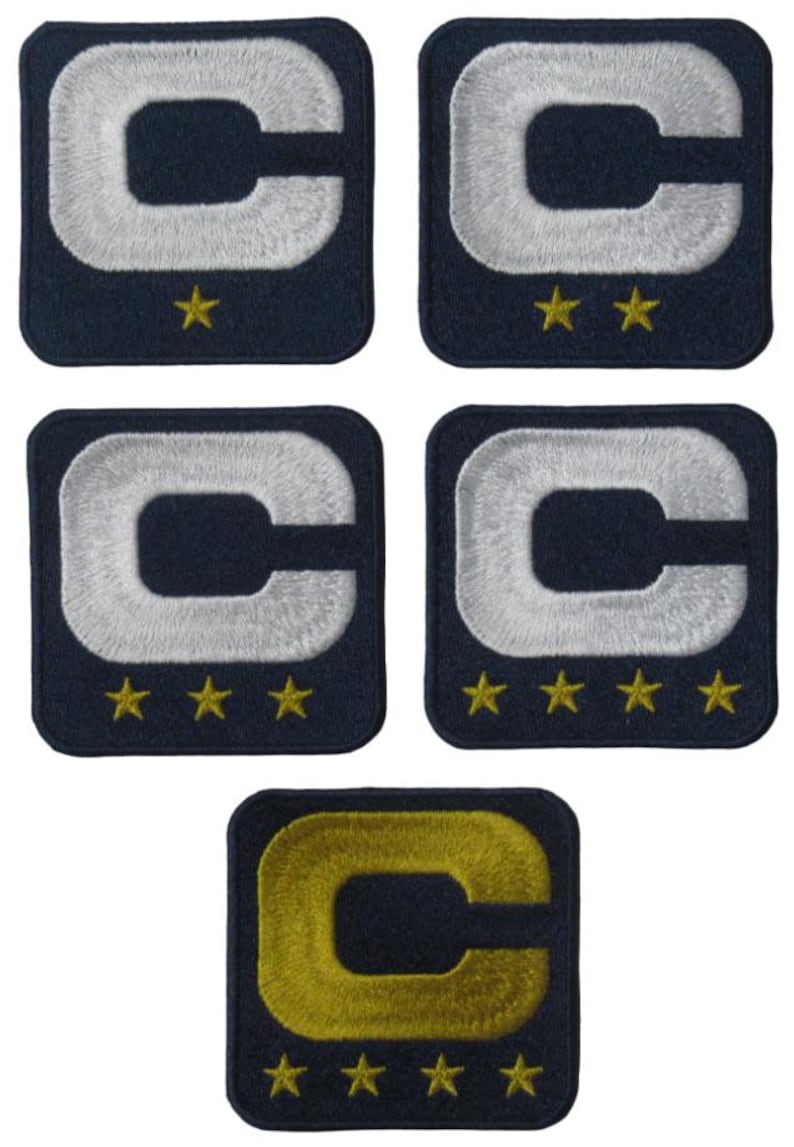 May include: Five navy blue embroidered patches. Each patch is a square with rounded corners. A white letter "C" is centered on each patch. Gold stars are below the "C". The bottom patch has a gold "C".