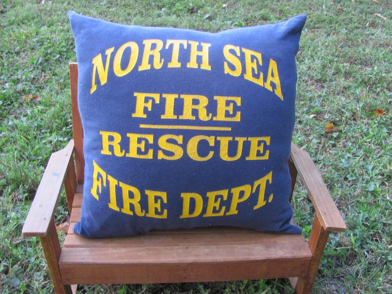 May include: A blue pillow with yellow text that reads "North Sea Fire Rescue Fire Dept."