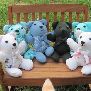 May include: A group of seven teddy bears sitting on a wooden bench. The bears are made of different fabrics and have different colors and patterns. The bears are all looking at the camera.