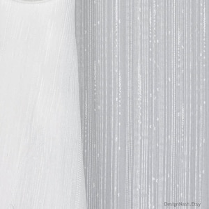 May include: White fabric with vertical lines and a textured appearance. The fabric has a delicate, semi-sheer quality, with subtle variations in the weave. The design is simple and elegant, suitable for curtains or other home decor items.