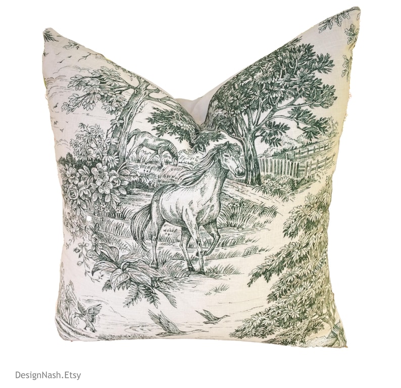 May include: A white pillow with a green and white horse and tree design. The design is reminiscent of a toile pattern.