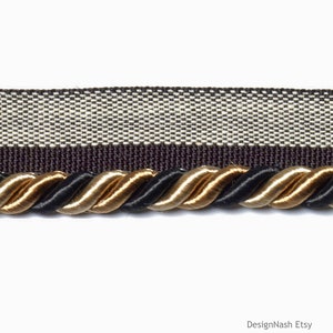 May include: Black, gold, and beige braided trim with a brown and white striped fabric backing.