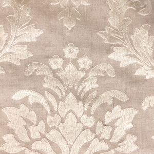 Peut inclure: Un tissu beige avec un motif floral brod&eacute; blanc. Le motif pr&eacute;sente un dessin r&eacute;p&eacute;titif de feuilles et de fleurs.