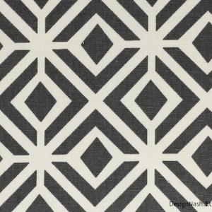 May include: Geometric pattern fabric featuring a repeating design of dark gray diamonds and white lines. The design creates a symmetrical, modern look. The fabric is suitable for various home decor projects.