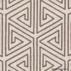 May include: A beige fabric with a geometric pattern of brown triangles and lines. The pattern is a repeating design of interlocking triangles.