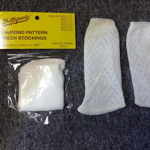 Puede incluir: Un par de medias de malla blanca con un patrón de diamante. Las medias están empaquetadas en una bolsa de plástico transparente con una etiqueta amarilla que dice "Diamond Pattern Mesh Stockings" y "Dollspart".