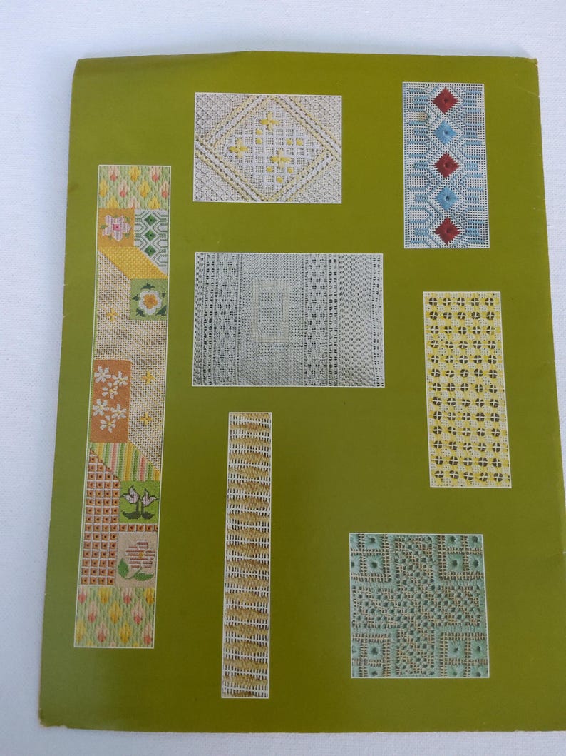 May include: A green paper featuring several needlepoint designs in white, yellow, red, and blue. The patterns include geometric shapes, floral designs, and diamond patterns. The paper has a vintage aesthetic.