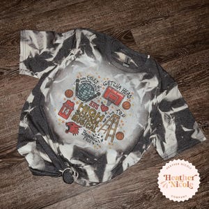Könnte beinhalten: Ein grau-weißes Batik-T-Shirt mit einem grafischen Design, das einen Basketball, eine Discokugel, eine Leiter und den Text "Getcha Head in the Game", "EHS High School Musical", "Bop to the Top" und "Breaking Free" zeigt.