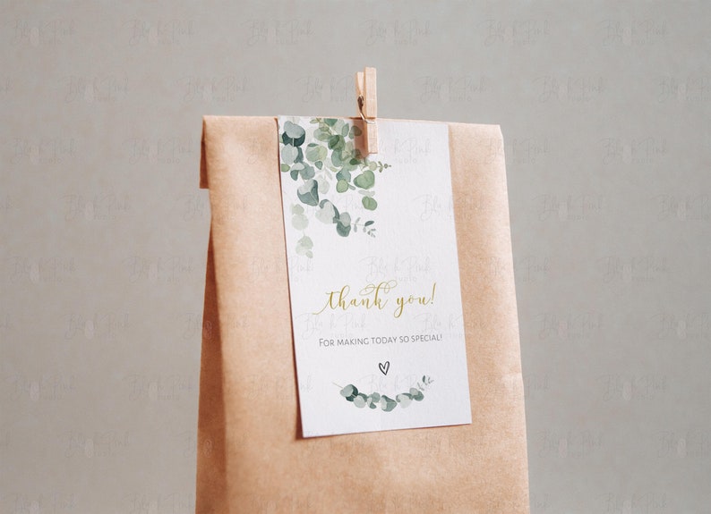 Puede incluir: Una etiqueta de agradecimiento blanca con hojas de eucalipto verde en acuarela y el texto "&iexcl;gracias! por hacer que este d&iacute;a sea tan especial!" en letras doradas. Un peque&ntilde;o coraz&oacute;n est&aacute; dibujado debajo del texto.