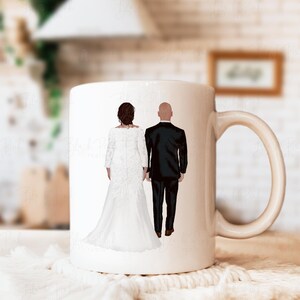 May include: A white ceramic mug featuring an illustration of a couple in wedding attire, holding hands. The bride is in a white gown, and the groom is in a black tuxedo. The mug has a curved handle.