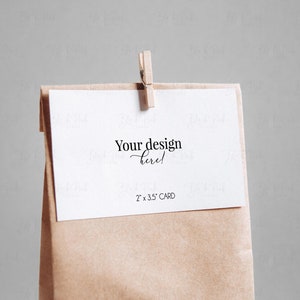 May include: A blank white card with the text "Your design here!" and "2" x "3.5" CARD" is clipped to a brown paper bag.