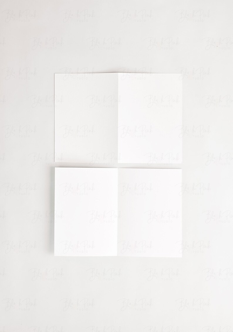 Puede incluir: Cuatro tarjetas blancas en blanco dobladas por la mitad, dispuestas en una cuadr&iacute;cula de dos por dos sobre un fondo blanco.