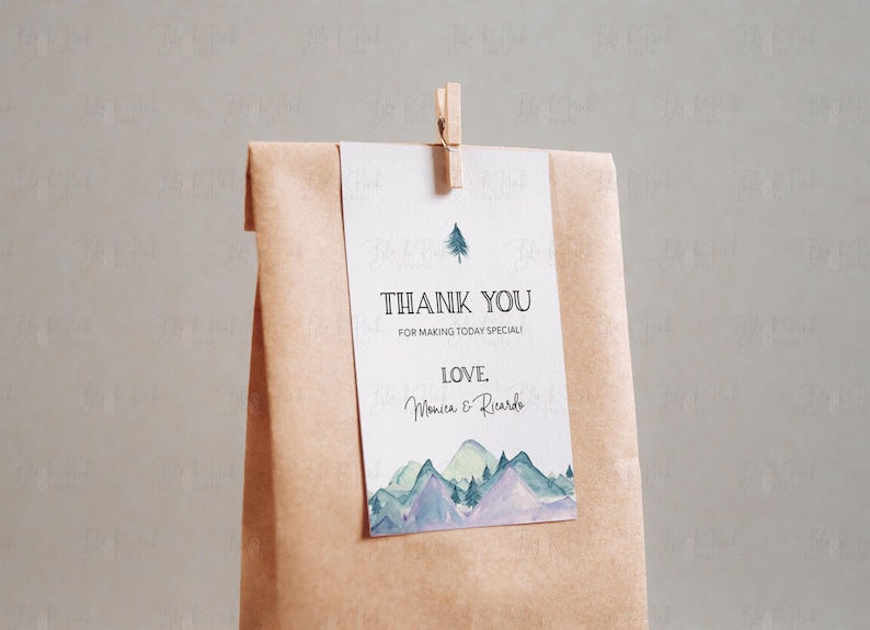 Puede incluir: Una etiqueta de agradecimiento con una ilustraci&oacute;n de acuarela de monta&ntilde;as y un pino. El texto dice "Gracias por hacer que este d&iacute;a sea especial! Con amor, Monica & Ricardo."