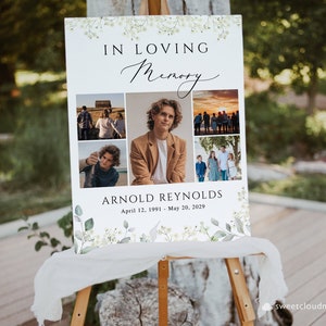 May include: A white memorial sign with a floral border and a collage of photos. The sign reads "In Loving Memory Arnold Reynolds April 12, 1991 - May 20, 2029".