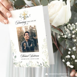 Può includere: Un programma funebre bianco con una croce dorata e foglie verdi. Il programma presenta una foto di un uomo con una giacca nera e una cornice dorata. Il testo recita "Honoring the Life of Michael Anderson January 21, 1970 - August 15, 20XX"