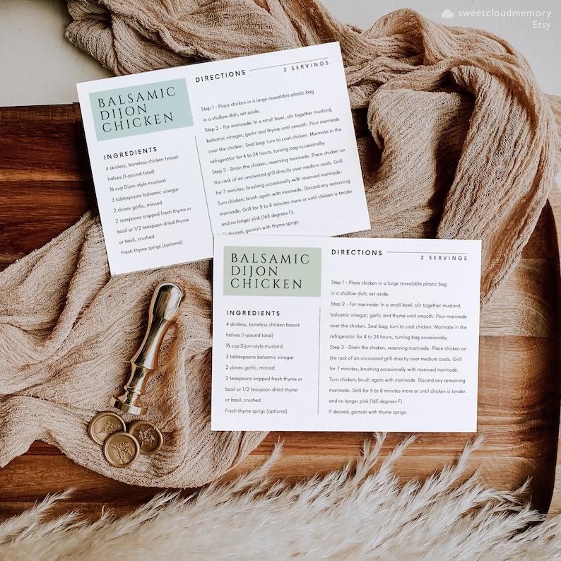May include: Printable recipe cards for Balsamic Dijon Chicken. The cards are white with green accents and feature the ingredients and directions for the recipe. The cards are on a wooden surface with a beige fabric and a gold wax seal.
