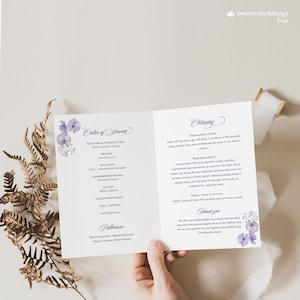 Op de afbeelding: Een paars en wit bloemen rouwprogramma met een dienstvolgorde en een overlijdensbericht. Het programma bevat de namen van de voorganger, de dragers en de overledene. Het overlijdensbericht bevat biografische informatie over de overledene.