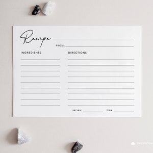 May include: A blank white recipe card with the word "Recipe" written in cursive at the top. The card is divided into two sections, one for ingredients and one for directions. There are lines for writing down the recipe. The card also has spaces for the name of the recipe, the number of servings, and the cooking time.