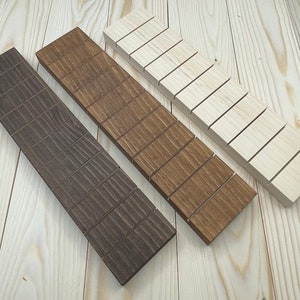 May include: Three wooden slatted trays in different shades of brown, from light to dark, on a light wood surface.