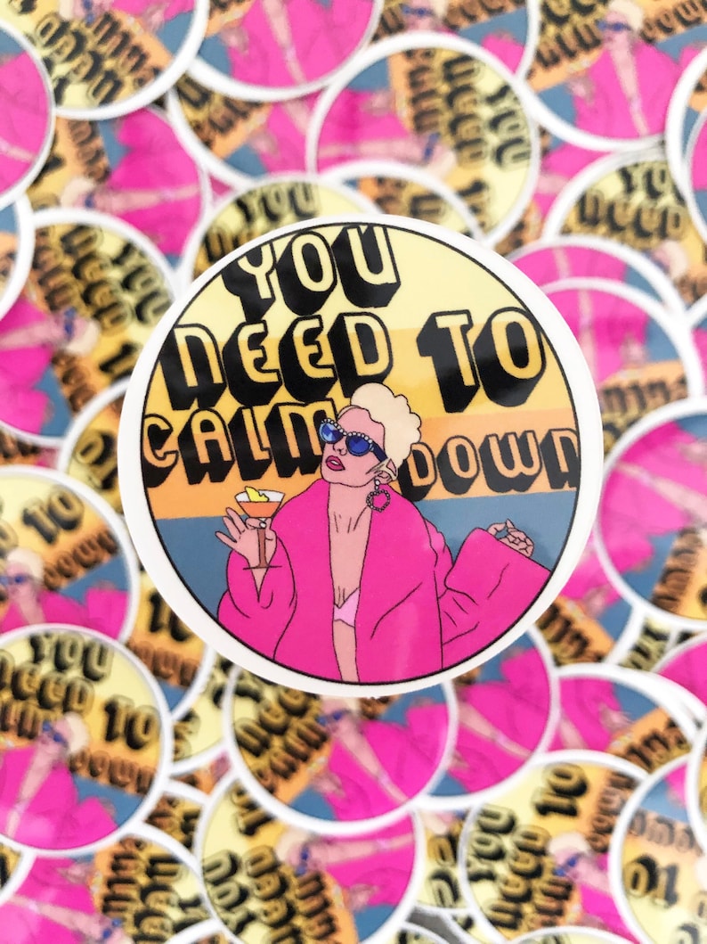 May include: A round sticker with a yellow background and the text "You Need To Calm Down" in black. A cartoon illustration of a woman with blonde hair wearing a pink robe and sunglasses is holding a martini glass.