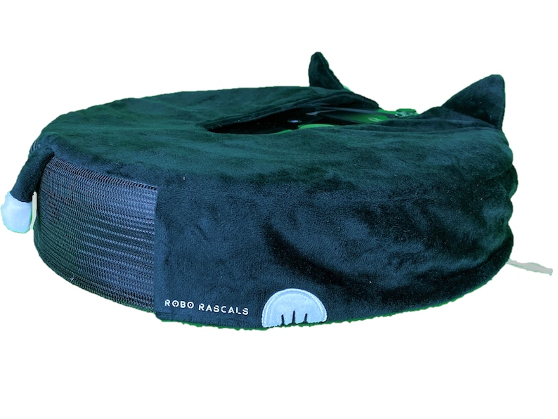 May include: A dark blue plush pet bed with a black mesh base and the text "ROBO RASCALS" on the side. The bed has two small ears on top.