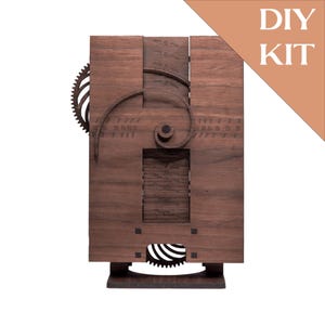 Könnte beinhalten: Ein DIY-Bausatz aus Holz für eine Uhr in Dunkelbraun. Die Uhr hat ein Zahnrad, ein Spiraldesign und einen rechteckigen Rahmen mit Zahlen. Die Worte "DIY KIT" befinden sich in der oberen rechten Ecke.