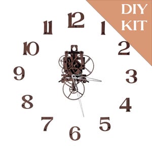 Puede incluir: Kit de reloj DIY con números de madera marrón y mecanismo de reloj. Los números están dispuestos en círculo, con el mecanismo del reloj en el centro. Las palabras "DIY KIT" están en la esquina superior derecha.