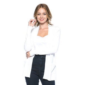 May include: A white open-front cardigan with long sleeves. The cardigan is made of a soft, knitted fabric and has a relaxed fit.