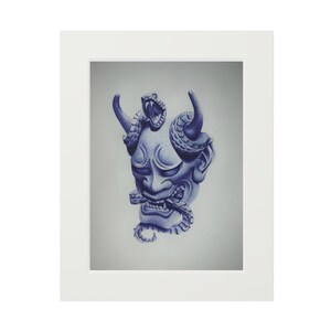Peut inclure: Dessin bleu et blanc d'un masque de démon japonais avec des cornes et un serpent enroulé autour. L'œuvre est encadrée dans un passe-partout blanc.