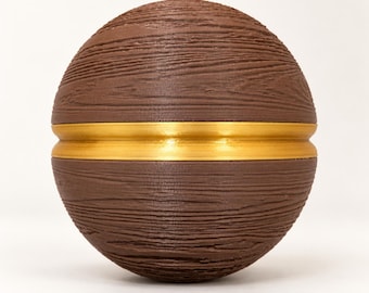 Könnte beinhalten: Ein kugelförmiges Objekt mit einer braunen, strukturierten Oberfläche, die an Holzmaserung erinnert. Die Kugel wird horizontal durch ein glattes, metallisch goldenes Band geteilt, das die Mitte umschließt und einen Kontrast bildet.