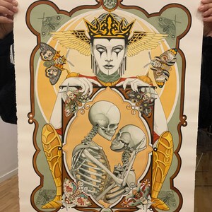 May include: A watercolor painting of a skeletal couple embracing within a golden frame. The couple is surrounded by moths and other insects. A crowned figure with wings and a painted face looks down at the couple.