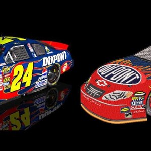 May include: Two stock car models featuring a red and blue paint scheme with yellow flame accents. The cars display the number 24 in yellow on the sides and roof, along with DuPont branding, Chevrolet logos, and various sponsor decals on the exterior.