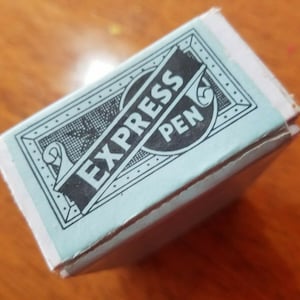Può includere: Una scatola blu e bianca con il testo "EXPRESS PEN" in lettere nere.