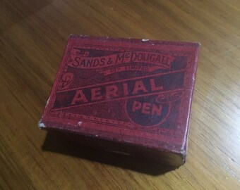 Könnte beinhalten: Eine rote Schachtel mit goldenen Lettern, auf der "Sands & McDougall, Ltd. Aerial Pen" steht.