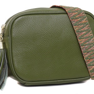 Peut inclure: Sac bandoulière vert olive avec une finition texturée. Il est doté d'une bandoulière à motifs verts, oranges et bruns. Une pampille et des accessoires dorés ajoutent des détails. Ce sac élégant est parfait pour un usage quotidien.