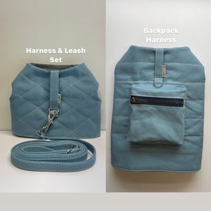 May include: A light blue quilted dog harness with a leash and a matching light blue quilted backpack harness. The backpack harness has a zippered pocket.