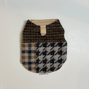 Puede incluir: Un chaleco para perro de cuadros marrones, negros y beige con un anillo en D de metal negro y una etiqueta de tela marrón que dice "FABQUILTEDBYFAISAL".