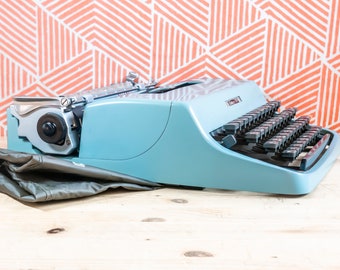 Zeer zeldzame eerste serie OLIVETTI LETTERA 32 1964! Gemaakt in Italië Blauwe handmatige draagbare perfect werkende typemachine + originele zachte kaft
