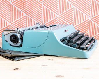 Zeer zeldzame eerste serie OLIVETTI LETTERA 32 1964! Gemaakt in Italië Blauwe handmatige draagbare perfect werkende typemachine + originele zachte kaft