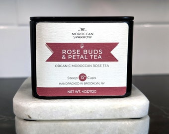 May include: A black tin container of Moroccan Sparrow Rose Buds & Petal Tea. The label is white with red accents and reads "Steep 15* Cups" and "Net Wt. 4oz/112g".