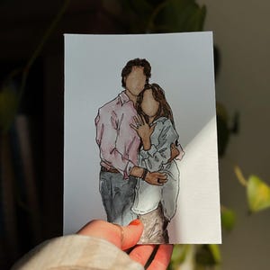 May include: A watercolor painting of a couple embracing. The man is wearing a pink button-down shirt and the woman is wearing a light blue shirt. They are both smiling.