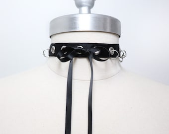 Choker with eyelets and piercings decorated with a bow