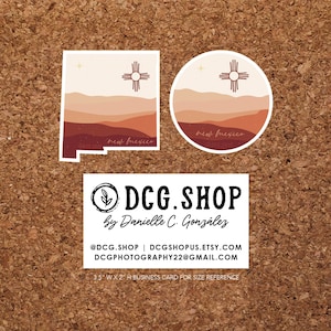 May include: Two sticker designs featuring a stylized depiction of the New Mexico state flag with a sunset landscape. The flag is a red sun symbol with four rays and a yellow circle in the center. The stickers are on a corkboard background. The text "new mexico" is written below the image. The text "DCG.SHOP by Danielle C. González" is written below the stickers. The text "@DCG.SHOP | DCGSHOPUS.ETSY.COM DCGPHOTOGRAPHY22@GMAIL.COM 3.5" WX 2" H BUSINESS CARD FOR SIZE REFERENCE" is written below the text.
