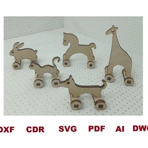 May include: Five wooden toy animals on wheels. The animals are a horse, a giraffe, a rabbit, a cat, and a dog. The toys are all made of unfinished wood and have simple, cartoonish designs.