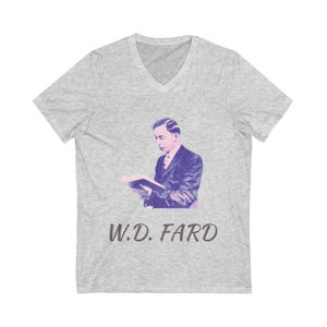 May include: A heather gray V-neck t-shirt featuring a vintage image of a man reading a book, with the text "W.D. FARD" printed below the image in a dark purple color. The shirt is made of a soft material.